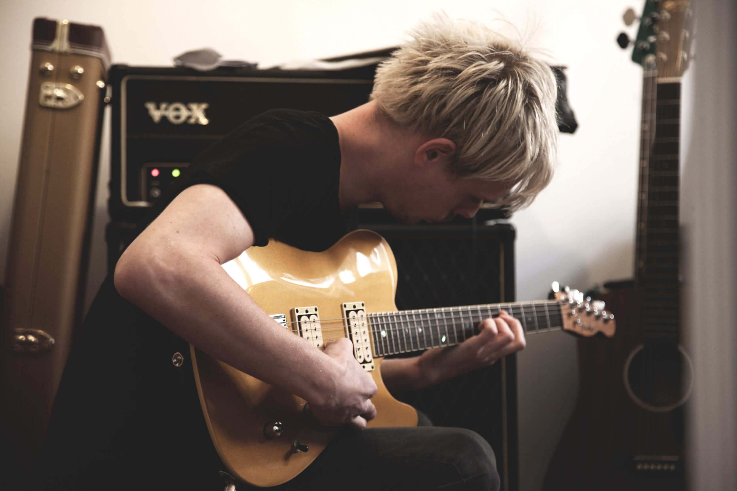 Cook Strummer playing Guitar on a Vox AC100 amplifier